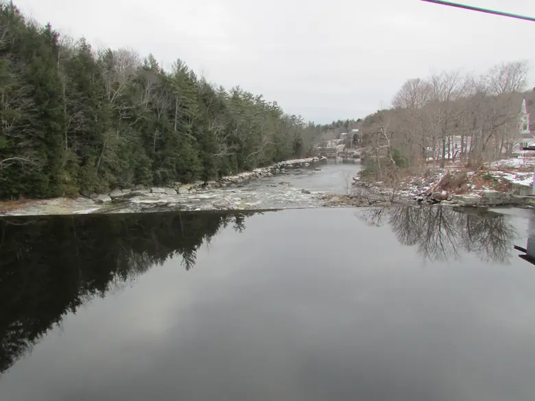 The Marsh River between snowy wooded banks in Frankfort, Maine, in winter