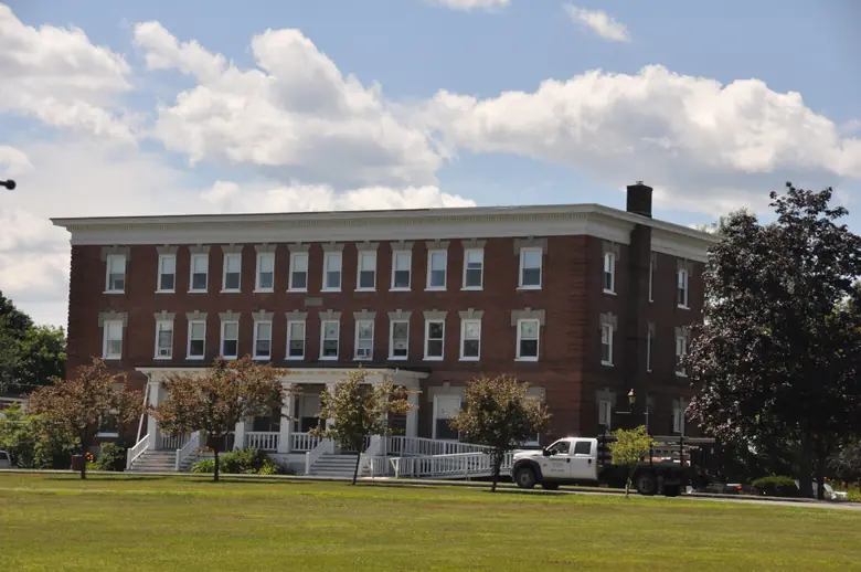 A brick building across a lawn on the Maine Central Institute campus in Pittsfield